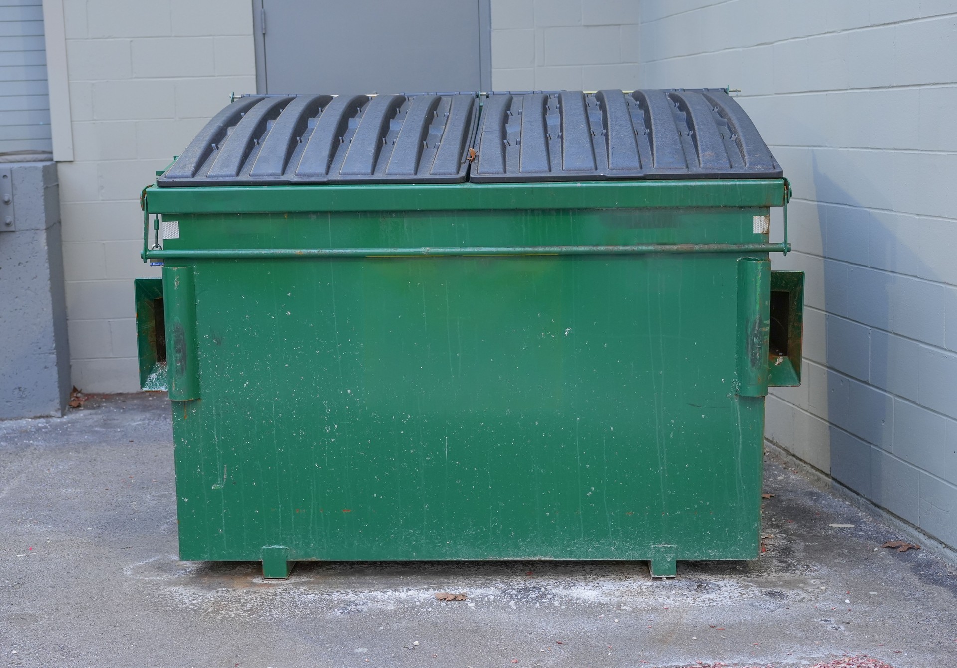 large green commercial dumpster for trash and recycling